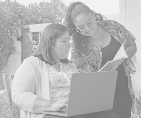 two women looking at a laptop compture